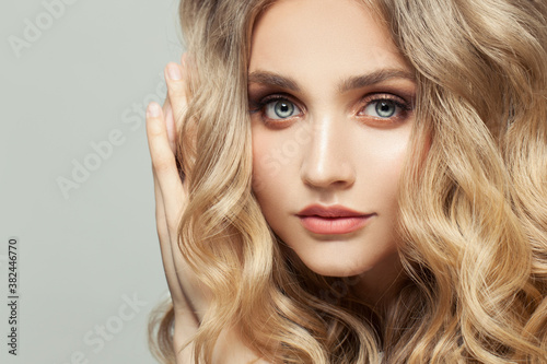 Close up portrait of cute young fashion model woman with long healthy curly hairstyle