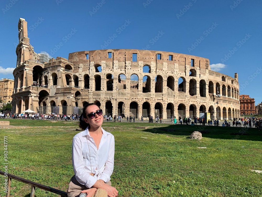 A cute girl sitting near Colosseum in Rome 