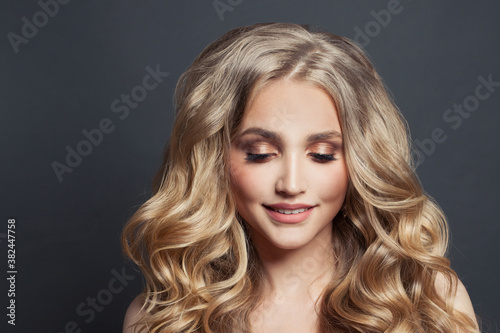 Hair model. Woman face with long healthy wavy hair on black background