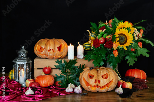 Pumpkins, candles, sunflower, leaves, lantern and other halloween attributes at the table as Halloween theme background