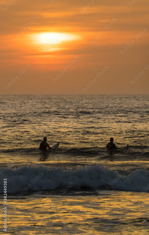 Sunrise over the atlantic ocean at St Augustine Beach in Florida. Two surfer wait for a big wave. Sunrise over the atlantic ocean at St Augustine Beach in Florida. Two surfer wait for a big wave.