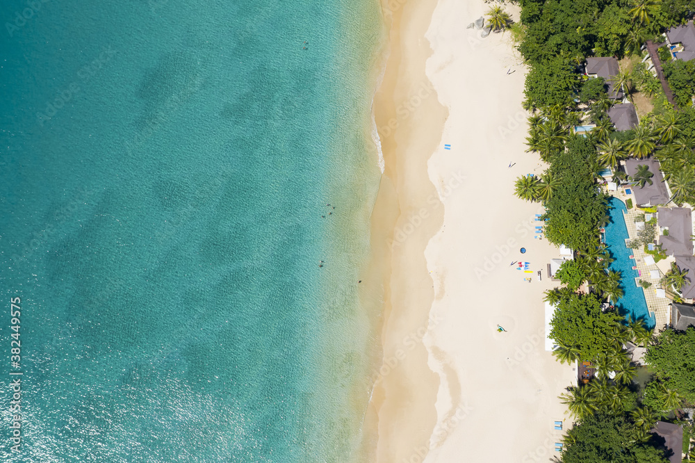 View from above, stunning aerial view of a beautiful white beach bathed by a turquoise, clear water. Surin beach, Phuket, Thailand.