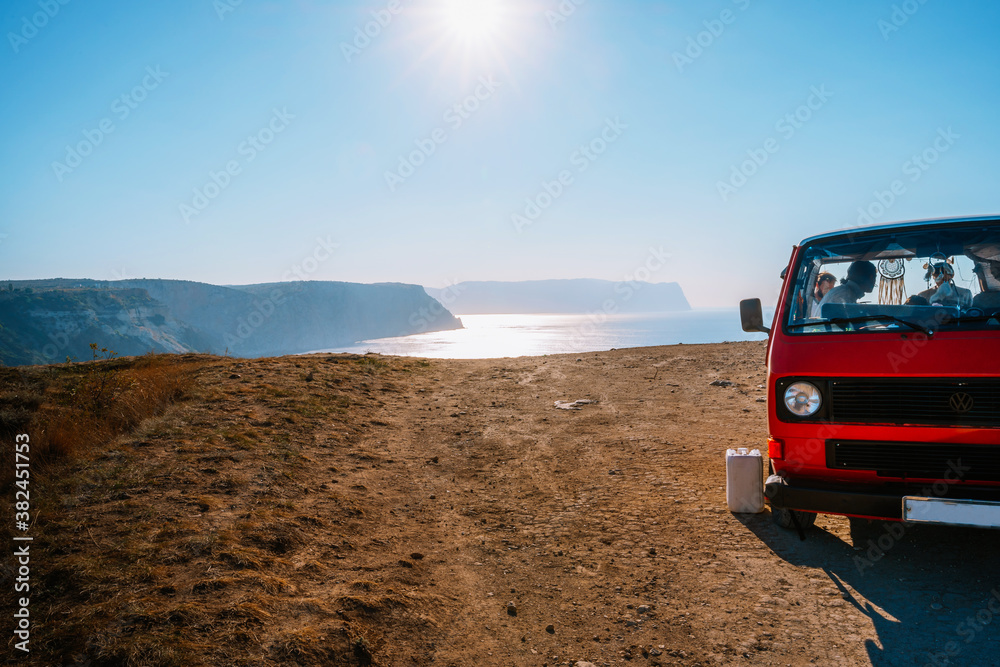 Travel van stands high above the sea with a view of the sea at dawn