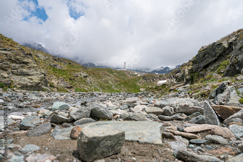 Picturesque alpine glacier stream flowing across granite stones. © anzebizjan