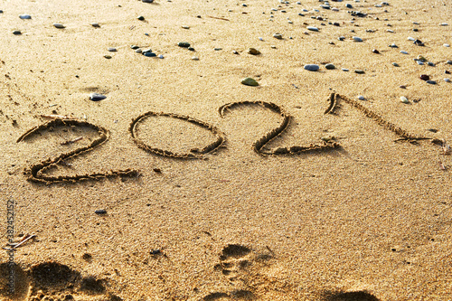 Happy new year 2021 text on the sea beach. Abstract background photo of the upcoming new year 2021 © pavasaris
