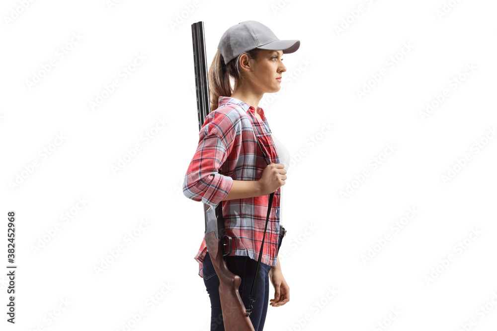 Young woman standing and holding a rifle on shoulder Young woman standing and holding a rifle on shoulder