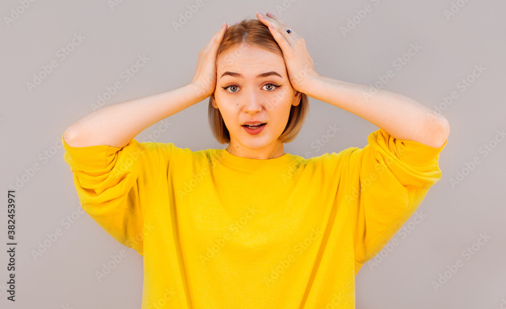 Surprised happy beautiful woman looking at camera in excitement. Isolated on gray background Surprised happy beautiful woman looking at camera in excitement. Isolated on gray background