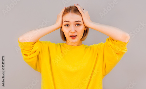 Surprised happy beautiful woman looking at camera in excitement. Isolated on gray background © Яна Солодкая