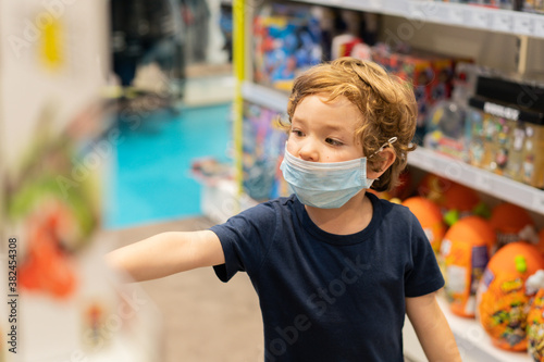The child wears a protective mask in the store. Safety, health protection during COVID-19 quarantine