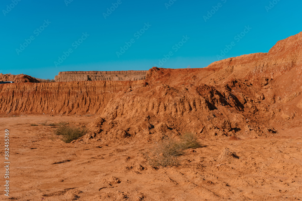 Rocky formations and mountains in sandy desert Rocky formations and mountains in sandy desert