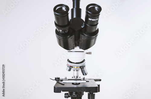 Using a biological microscope. Close up of a microscope. Scientific research concept, using a microscope. Medical examinations, searching for bacteria, diseases, blood tests.