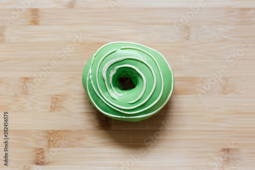 Top view of green donut on wooden table.