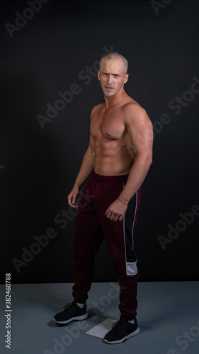 фотографія Pumped athlete looks like Jason Statham on a black background of a strong muscul