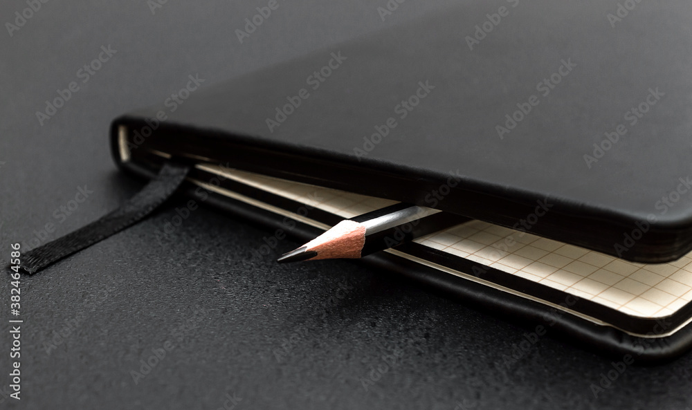 Pencil with notepad on black background. Close up. Pencil with notepad on black background. Close up.