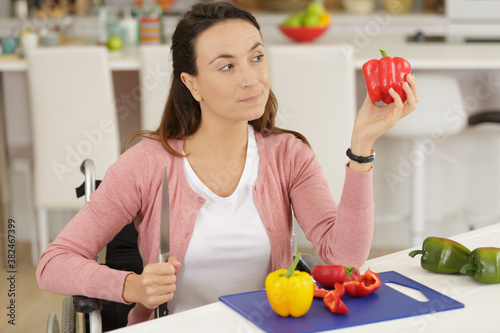 disabled woman in wheelchair preparing meal in kitchen