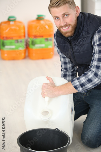 Fotografia man with pour fuel in a bucket