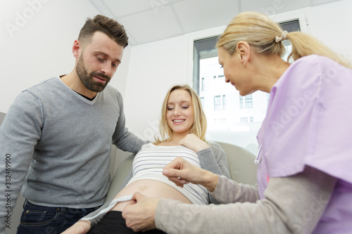friendly doctor with pregant woman with her husband
