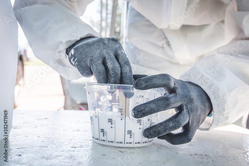 Hands of the worker in black rubber (selikon) gloves. Painting works, epoxy resin