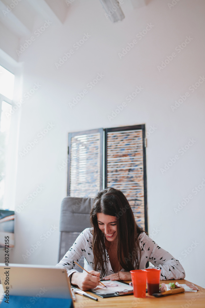 Young beautiful brunette woman smiling and doing watercolor art Young beautiful brunette woman smiling and doing watercolor art