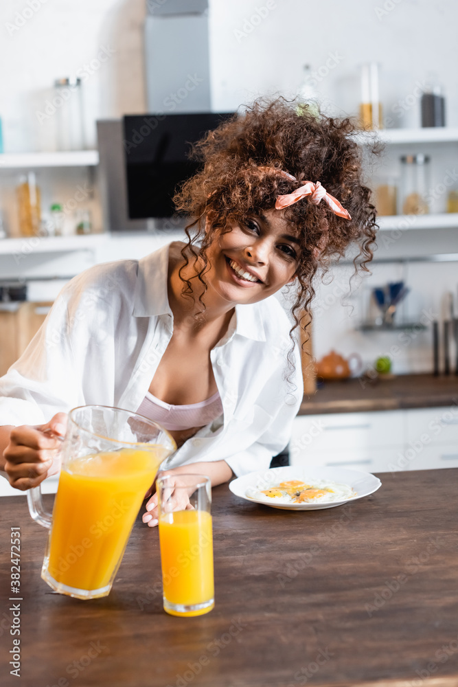 joyful woman holding jug near glass and breakfast on plate joyful woman holding jug near glass and breakfast on plate