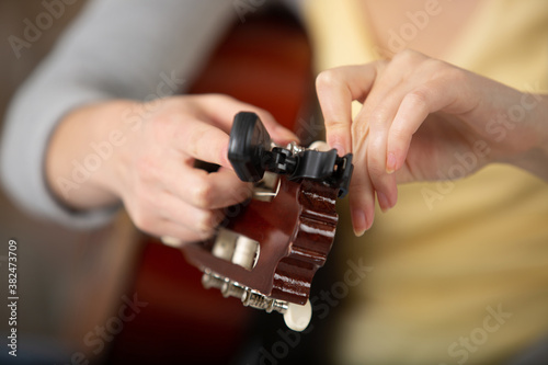 close-up portrait of hands playing an acoustic guitar
