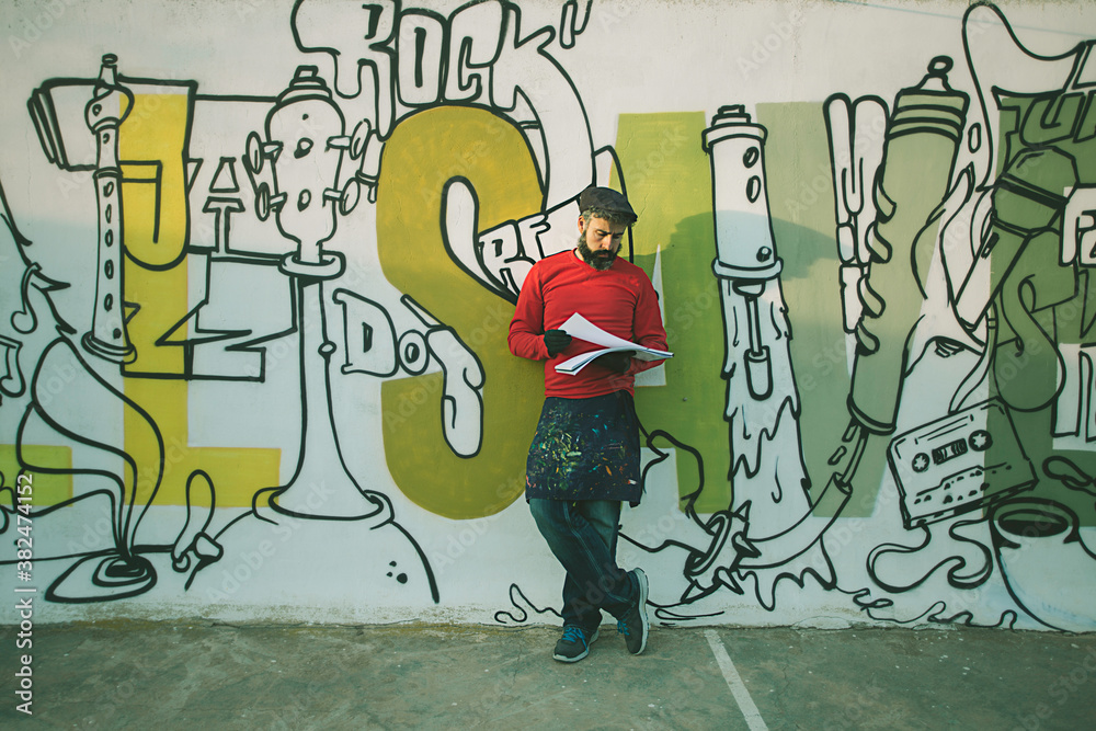 Man painting in a graffiti wall Man painting in a graffiti wall
