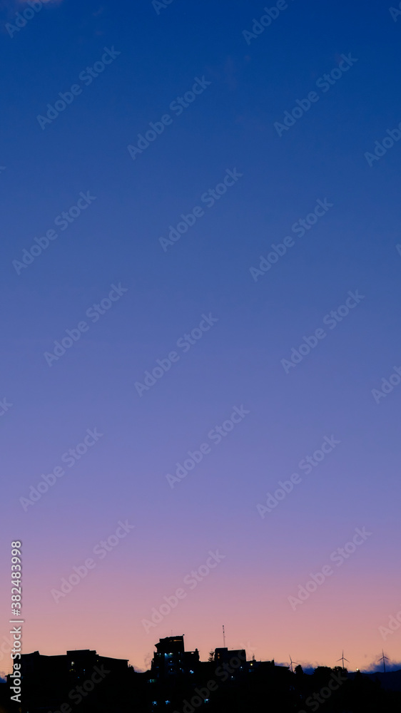 Sunset with clear purple sky with city silhouette