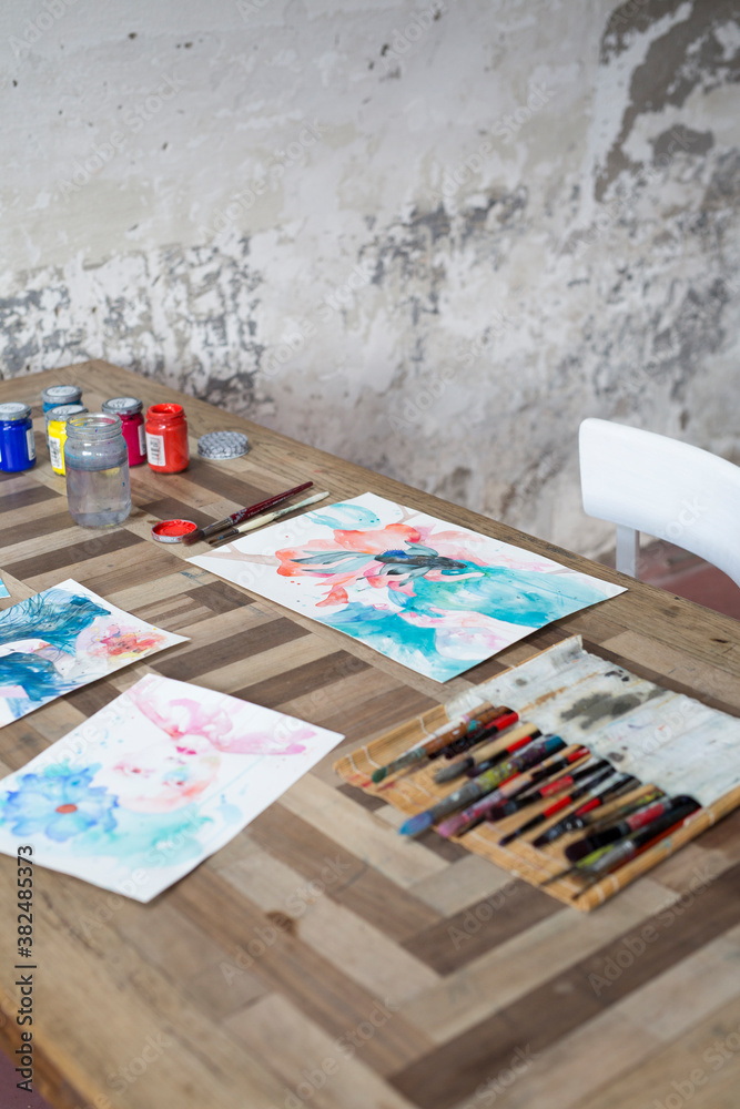 Desk with paintings and brushes Desk with paintings and brushes