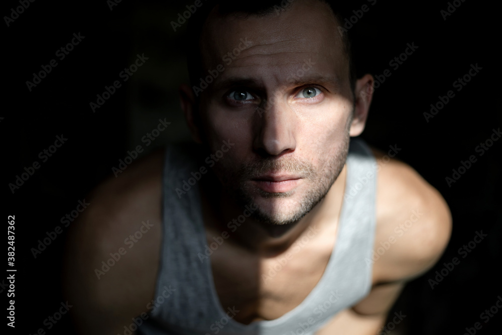 portrait of a young man looking out of the dark