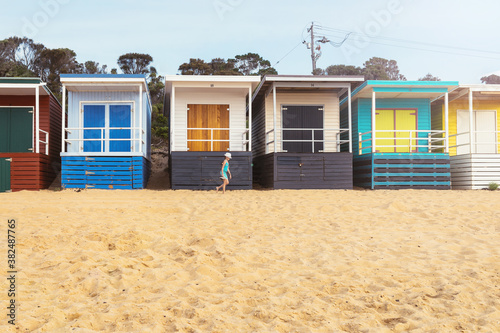 tween girl walking in front of a row of bathing huts at Mt Marth photo