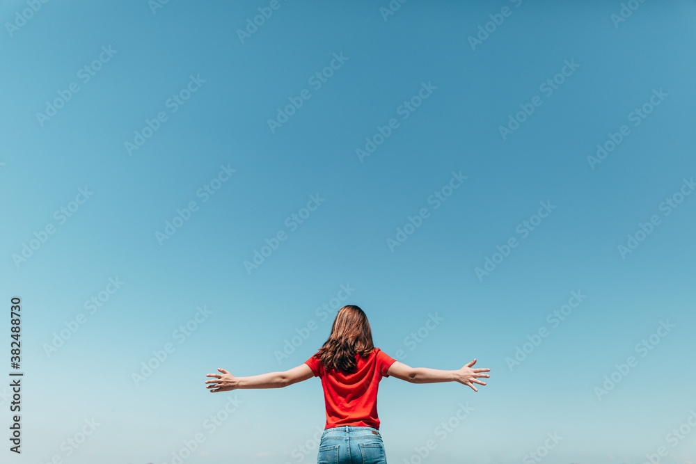 Teenager with Arms Wide Open to a Clear Blue Sky Teenager with Arms Wide Open to a Clear Blue Sky