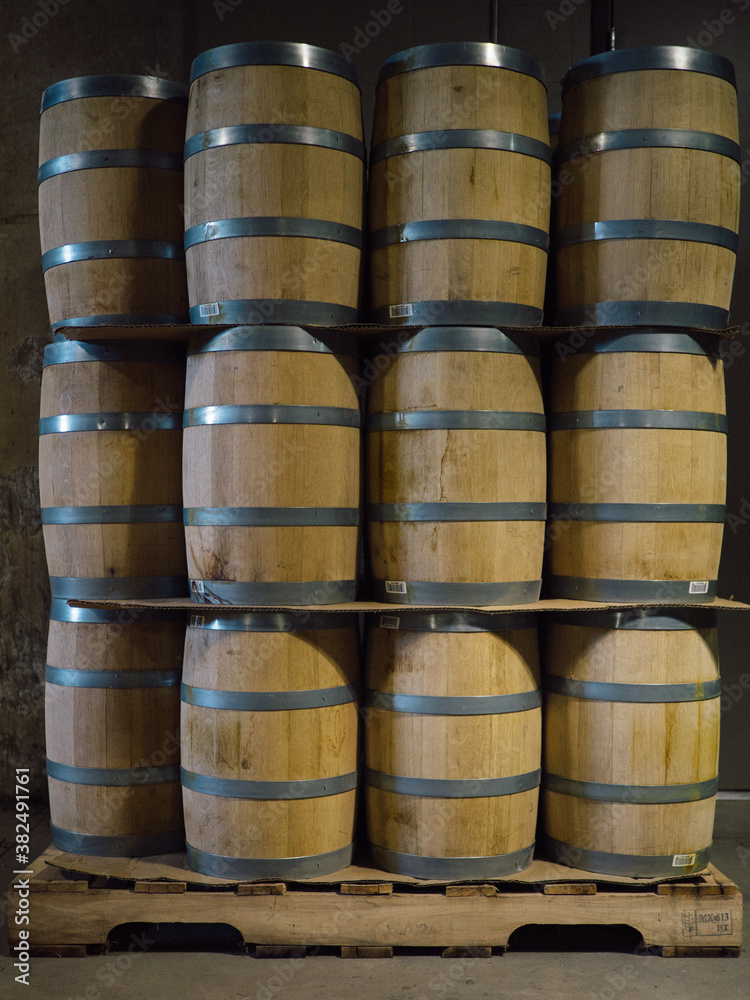 Wooden barrels stacked in whiskey distillery factory Wooden barrels stacked in whiskey distillery factory