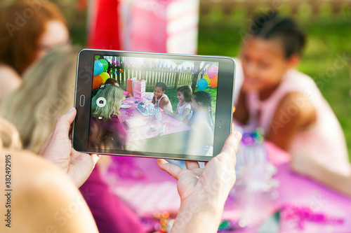 Birthday: Mom Takes A Photo While Girl Prepares To Blow Out Cand photo