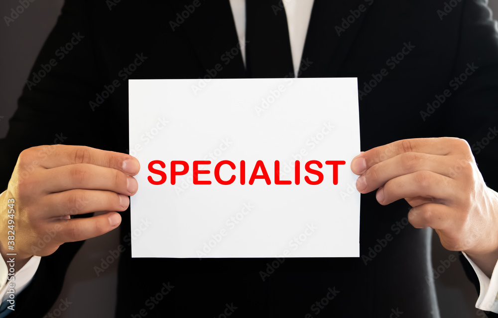 The girl holds a card with the inscription SPECIALIST. The girl holds a card with the inscription SPECIALIST.