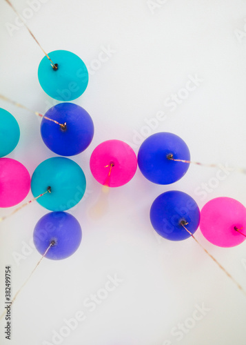 Many ballons in different colors with gold sequin strings seen from below photo