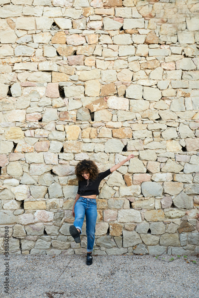 Cheerful brunette with afro with arm and kick leg up Cheerful brunette with afro with arm and kick leg up