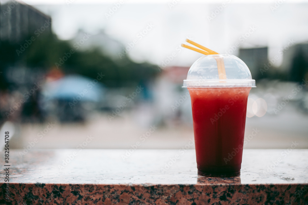 Red raspberry drink in a plastic glass with a straw Red raspberry drink in a plastic glass with a straw