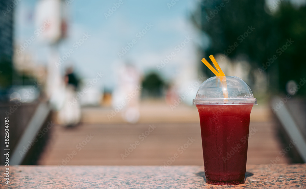 Fototapeta Red raspberry drink in a plastic glass with a straw
