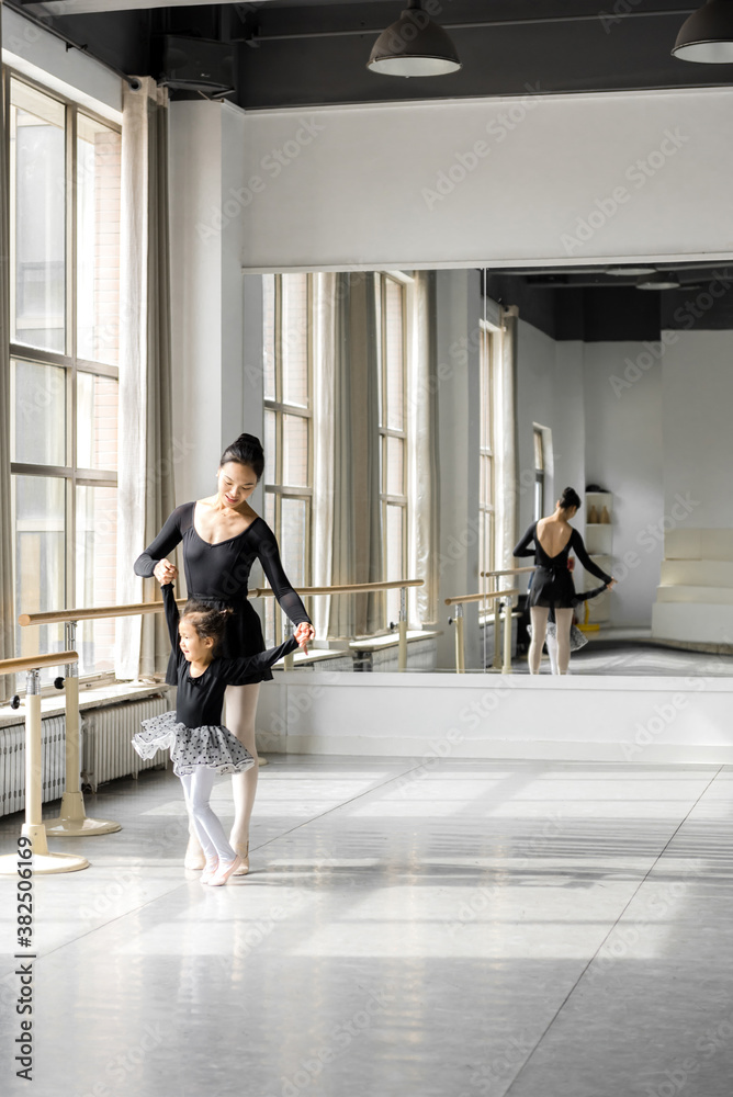 Female ballet instructor teaching girl in ballet studio Female ballet instructor teaching girl in ballet studio