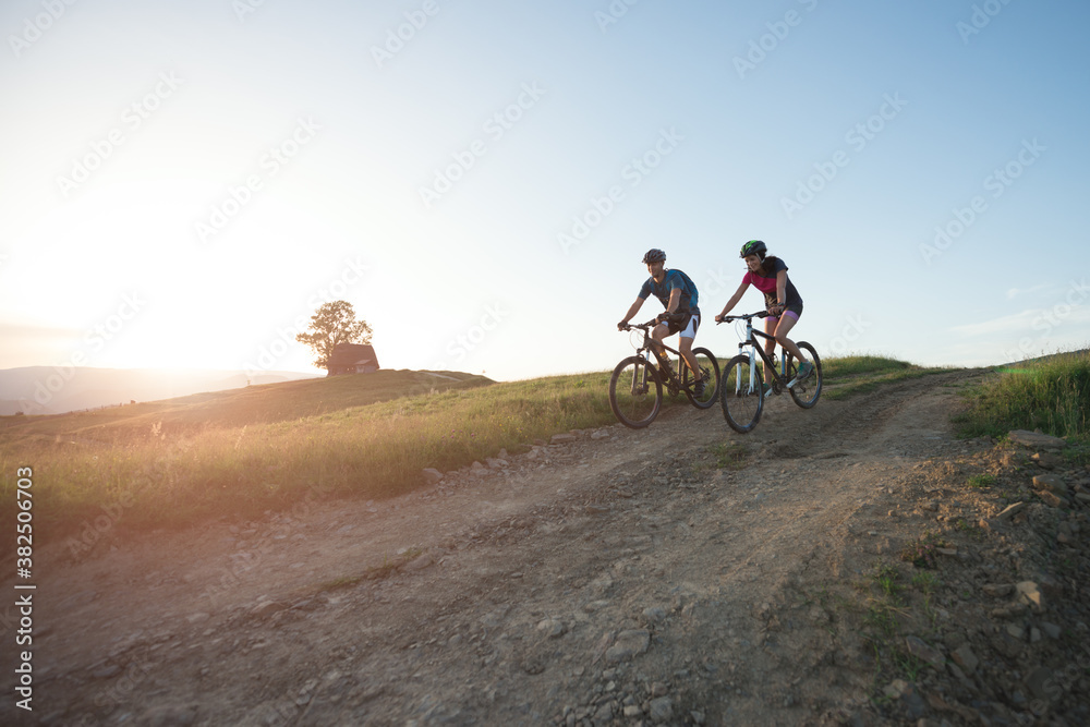 Bikers riding downhill a countryside road during twilight Bikers riding downhill a countryside road during twilight
