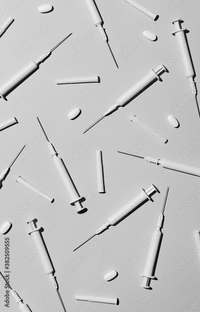 Blanc hypodermic needles adn pills on white background.