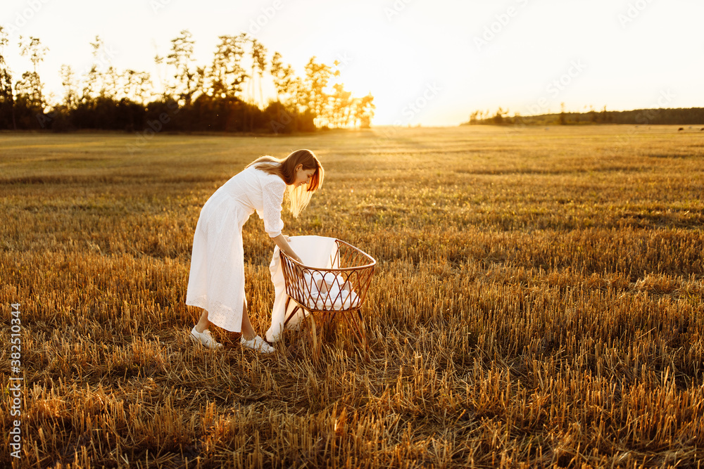 Beautiful woman with beautiful newborn baby girl at the field, loving mother take care of little daughter, tender family moments, parenting and maternity concept Beautiful woman with beautiful newborn baby girl at the field, loving mother take care of little daughter, tender family moments, parenting and maternity concept