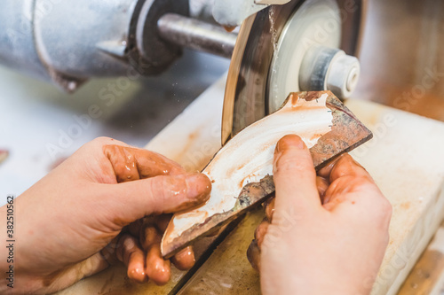 Artisan Woman Cutting Stone with a Circular Saw for Mosaic Artwo photo