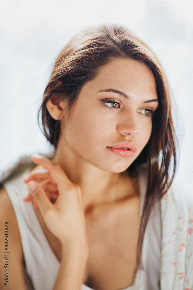 Half italian and half brazilian woman relaxes with quilt on her shoulder close to window Half italian and half brazilian woman relaxes with quilt on her shoulder close to window