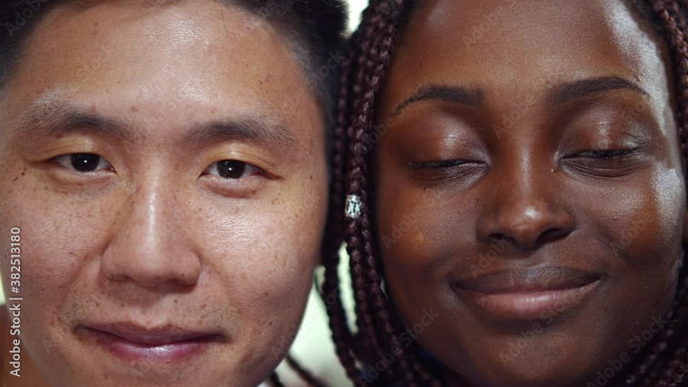 Close up of cheerful multiracial millennial couple smiling at camera Close up of cheerful multiracial millennial couple smiling at camera
