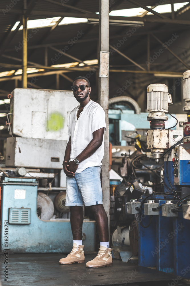 Portrait photo young stylish black man in a white T-shirt and glasses in old factory. Street photo. african american people. Portrait photo young stylish black man in a white T-shirt and glasses in old factory. Street photo. african american people.