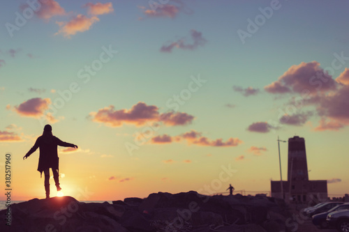 Woman at sunset by the old lighthouse