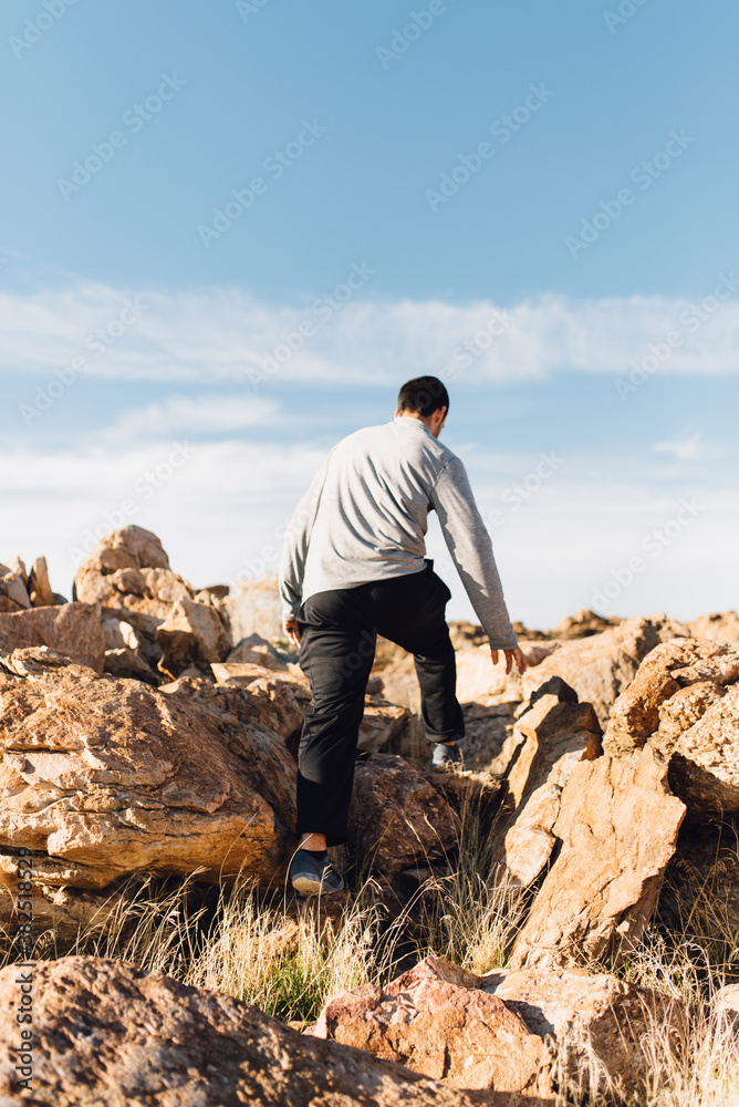 A man hiking through desert mountains A man hiking through desert mountains