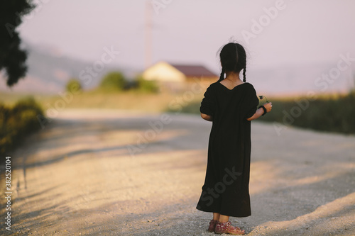 Little girl looking at abandoned house photo