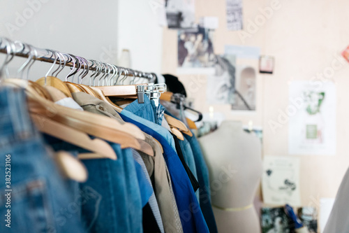 vintage clothing pieces hung on rack in diy fashion studio workshop space photo